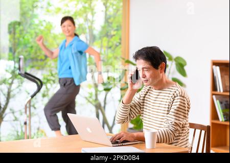 Telearbeit, Mann und Frau mittleren Alters, die Laufmaschine spielen Stockfoto