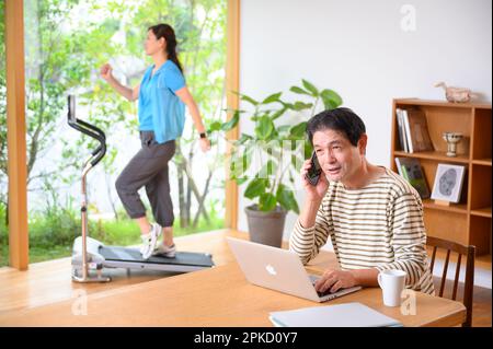 Telearbeit, Mann und Frau mittleren Alters, die Laufmaschine spielen Stockfoto