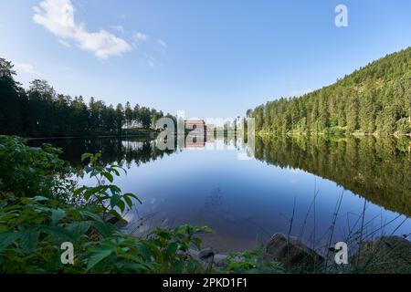 Hornisgrinde, Deutschland - 11. August 2021: See (Mummelsee) im Schwarzwald früh am Morgen. Berghotel für Übernachtungen auf der anderen Seite Stockfoto