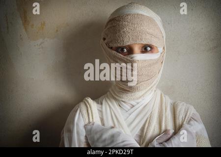 Frau in Bandagen gewickelt, als ägyptische Mumie-Halloween-Kostüm Stockfoto