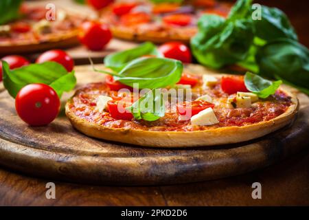 Traditionelle hausgemachte Pizza mit Salami und Basilikum Stockfoto