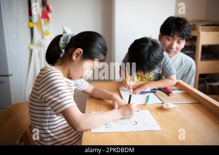 Eltern und Kinder versammelten sich am Schreibtisch Stockfoto