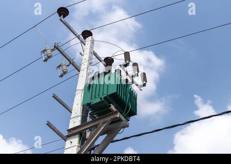 Details der Hochspannungsleitung auf einem Betonmast montiert. Hochspannungssicherungen, Isolatoren und Transformatoren Stockfoto