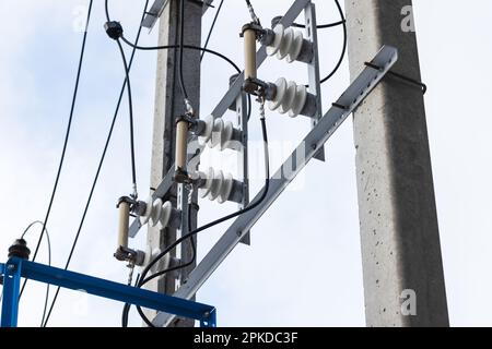 Details der Hochspannungsleitung auf einem Betonmast montiert. Hochspannungssicherungen Stockfoto