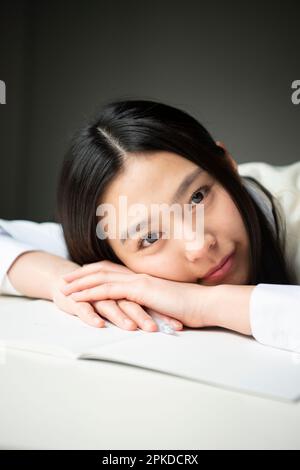 High-School-Mädchen auf einem Tisch liegend Stockfoto