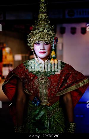 Eine junge thailändische Frau in traditionellem thailändischem Kostüm und mit Kopfkleid; verkleidet für Halloween-Feiern in Khao San Road, Bangkok. Thailand Stockfoto