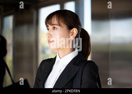 Frau im Anzug, die im Aufzug sitzt Stockfoto