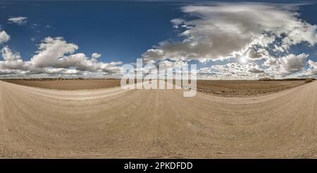 Kugelförmiges 360-Hdri-Panorama auf Schotterstraßen mit Wolken und Sonne auf blauem Himmel in gleicheckiger nahtloser Projektion, als Himmelsersatz in Drohnenpfanne Stockfoto