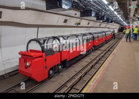 Einer der angepassten Touristenzüge von Mail Rail, dem ehemaligen Postamt-Eisenbahnsystem unter den Straßen von Central London, Vereinigtes Königreich. Stockfoto