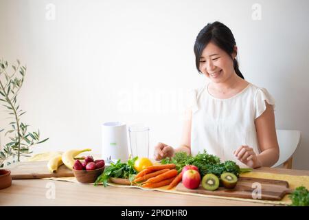 Eine Frau, die Zutaten für einen Smoothie aussucht Stockfoto