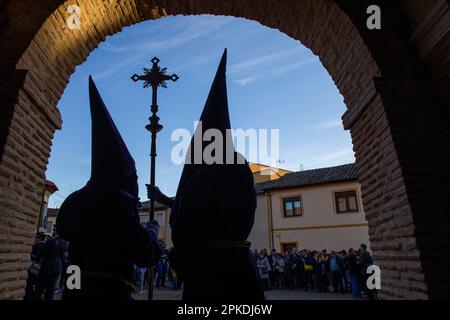 Während der Prozession am Heiligen Donnerstag, die durch die Hauptstraßen von Sahagun ging, halten zwei Bußgesellen das Kreuz unter dem Bogen der Kirche San Lorenzo. (Foto: Luis Soto/SOPA Images/Sipa USA) Guthaben: SIPA USA/Alamy Live News Stockfoto