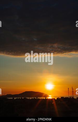 Ein Sonnenuntergang mit einer dunklen Wolke am Himmel Stockfoto