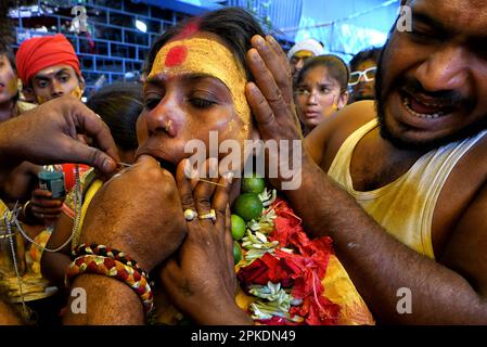 Bandel, Indien. 06. April 2023. Eine Frau, die während des religiösen Festivals Vel Vel in Westbengalen von einem Speer (auch als göttlicher Speer bekannt) durchbohrt wurde. Velvel ist ein Hindu-Festival, das dem Hindu-Gott Murugan/Mutthumariamman gewidmet ist und im April gefeiert wird. Die Gläubigen führen verschiedene schmerzhafte Rituale durch, oft mit Piercing, in der Überzeugung, dass Gott Murugan/Mutthumariamman ihre Familienmitglieder für das nächste Jahr vor allen bösen Mächten retten wird. Kredit: SOPA Images Limited/Alamy Live News Stockfoto