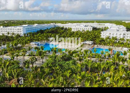 Luxusresort. Hotel mit Luftblick, umgebendes Gebiet mit Meeresküste, Swimmingpools und grünen Palmen. Landschaft mit modernem Hotel am Meer, blaues Wasser, Sandstrand, grüne Bäume, Gebäude. Stockfoto