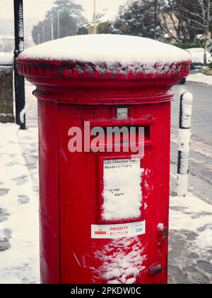 Roter Postkasten von Royal Mail mit Schnee überzogen. Bath, UK, März 2023. Stockfoto