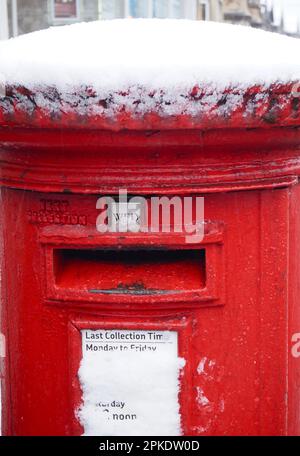 Roter Postkasten von Royal Mail mit Schnee überzogen. Bath, UK, März 2023. Stockfoto