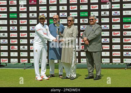 Shakib Al Hansan holt sich die Testtrophäe vom BCB-Präsidenten Nazmul Hasan, als Bangladesch Irland eine siebenfache Niederlage überreichte, als die Heimat hinter d her war Stockfoto