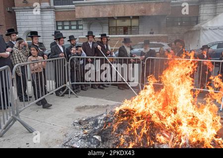 Am Morgen vor dem Passover beten die Juden zusammen an einem Lagerfeuer, das die letzten Brotprodukte vor dem Feiertag verbrennt. In Brooklyn, New York. Stockfoto