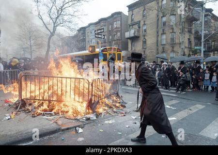 Stunden vor dem Passover verbrennen chassidische Männer und Jungen ihre verbliebenen Brotprodukte an einem Lagerfeuer auf der Bedford Avenue in Williamsburg, Brooklyn, NYC. Stockfoto