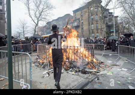 Stunden vor dem Passover verbrennen chassidische Männer und Jungen ihre verbliebenen Brotprodukte an einem Lagerfeuer auf der Bedford Avenue in Williamsburg, Brooklyn, NYC. Stockfoto