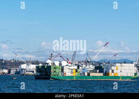 Ein Containerschiff, beladen mit einer Ladung von Containern, verlässt Harbor Island im Industriegebiet von Seattle. Stockfoto