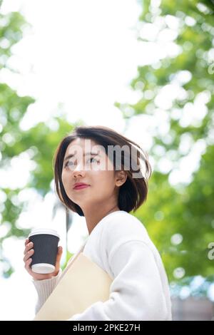 Frau mit Kaffee und Feile Stockfoto