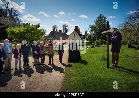 Thaxted, England, Gb 07. April 2023. Thaxted Essex UK Zeugenprozession am Karfreitag 7. April 2023 Daniel Fox trägt das christliche Kreuz der Opfer, während er die Prozession am Osterfreitagmorgen durch die wunderschöne Stadt Thaxted im Nordwesten von Essex führt. Hier mit Thaxted Alms House und Chantry und Hohn Webbs Windmill im Hintergrund. Kredit: BRIAN HARRIS/Alamy Live News Stockfoto