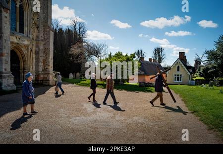 Thaxted, England, Gb 07. April 2023. Thaxted Essex UK Zeugenprozession am Karfreitag 7. April 2023 Daniel Fox trägt das christliche Kreuz der Opfer, während er die Prozession am Osterfreitagmorgen durch die wunderschöne Stadt Thaxted im Nordwesten von Essex führt. Hier mit Thaxted Alms House und Chantry und Hohn Webbs Windmill im Hintergrund. Kredit: BRIAN HARRIS/Alamy Live News Stockfoto