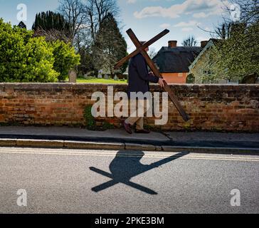 Thaxted, England, Gb 07. April 2023. Thaxted Essex UK Zeugenprozession am Karfreitag 7. April 2023 Daniel Fox trägt das christliche Kreuz der Opfer, während er die Prozession am Osterfreitagmorgen durch die wunderschöne Stadt Thaxted im Nordwesten von Essex führt. Kredit: BRIAN HARRIS/Alamy Live News Stockfoto