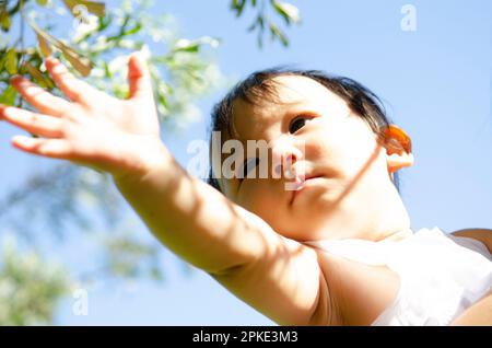 Baby streckt seine Hand aus Stockfoto