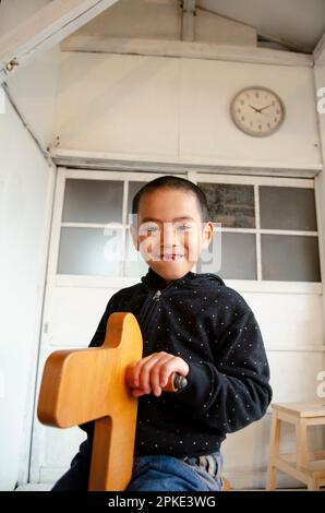 Ein Junge, der auf einem Holzpferd spielt Stockfoto