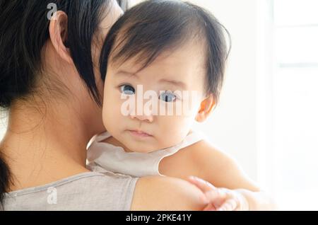 Baby von der Mutter getragen werden Stockfoto