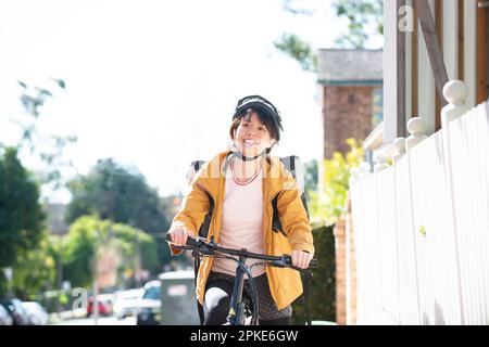 Eine Frau, die Essen auf einem Fahrrad liefert Stockfoto