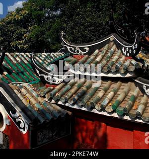 Elegante, geschwungene, in Schwarz und Weiß dekorierte Flugheber ziehen nach oben über grüne, halbrunde Keramikfliesen auf einem typischen traditionellen Dach über einem Pavillon des A-Ma Tempels in Macau, China. Der Tempel stammt aus dem Jahr 1488 n. Chr. und steht dort, wo A-Ma oder Tin Hau, die taoistische Muttergöttin und Beschützerin der Seeleute, nach einem Sturm sicher in einem Fischerboot gelandet sind, bevor sie in den Himmel aufstieg. Stockfoto