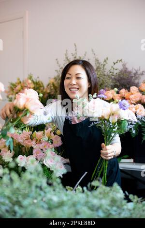 Lächelnde Frau, die beim Floristen arbeitet Stockfoto