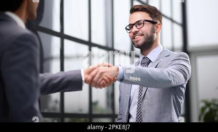 Glückliche Geschäftsmänner begrüßen sich im Büro. Stockfoto