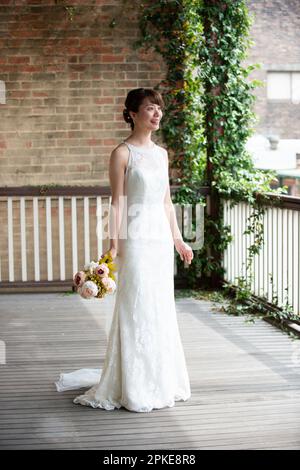 Eine Frau, die im Hochzeitskleid lacht Stockfoto