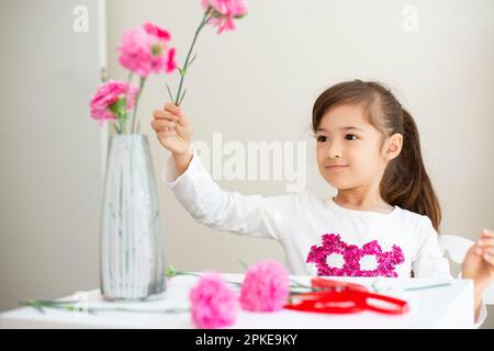 Mädchen mit Nelke in Vase Stockfoto