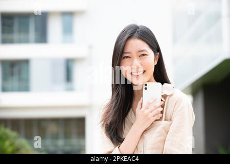 Eine Frau, die mit ihrem Handy lächelt Stockfoto