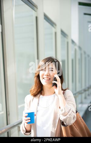 Lächelnde Frau, die am Telefon läuft Stockfoto