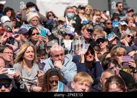 Trafalgar Square, Westminster, London, Großbritannien. 7. April 2023. Der Tag hat warm und sonnig begonnen, und während der Aufführung der Leidenschaft Jesu auf dem Trafalgar Square nutzen die Leute Veranstaltungsprogramme für Schatten. Kostenlose öffentliche Veranstaltung. Stockfoto