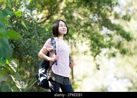 Frau im Wald mit Rucksack auf dem Rücken Stockfoto