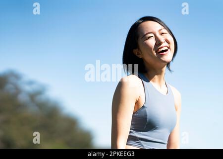 Eine Frau, die in Trainingskleidung lacht Stockfoto