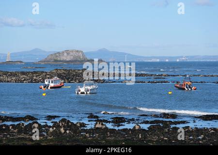 North Berwick, Schottland, Großbritannien. 07. April 2023 Ein herrlicher, sonniger Start in den Morgen bringt Osterurlauber-Besucher und Einheimische an die Strände von North Berwick. Blick auf die vierte Flussmündung und Isle of Lamb vom West Bay Beach, Blick auf Fife. Kredit: Craig Brown/Alamy Live News Stockfoto