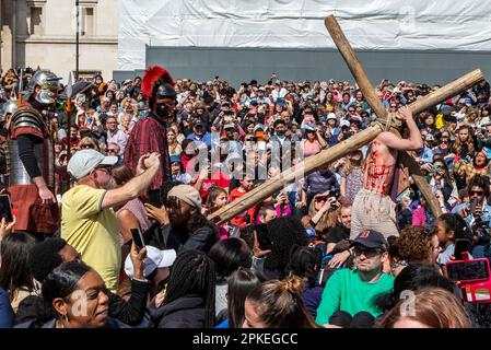 Trafalgar Square, London, Großbritannien. 7. April 2023. Am Karfreitag an Ostern präsentierte Wintershall die „Leidenschaft Jesu“, ein Stück nach der bibelgeschichte Christi durch die „Wunder“, das letzte Abendmahl, Und die Kreuzigung durch die Hände der Römer, bevor sie sich wieder erheben für die Auferstehung, alle benutzten den Trafalgar Square als Bühne für diese kostenlose öffentliche Veranstaltung. Eine große Menschenmenge in den vielen Tausenden, die auf dem Platz eingepackt sind, und dabei Christus beim Schauspieler Peter Bergin beobachten, der hier das Kreuz durch das Publikum trägt Stockfoto