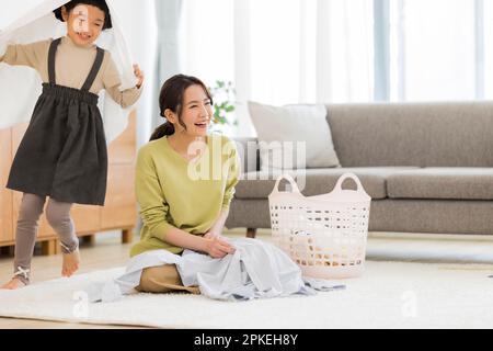 Faltbare Wäscherei für Mutter und Mädchen mit Handtuch bedeckt Stockfoto