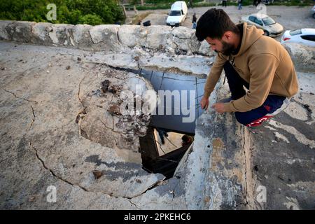 Beirut, Libanon. 7. April 2023. Ein Mann überprüft das beschädigte Dach eines Hauses im israelischen Luftangriff, der einen Garten nahe der Stadt Tyre, Südlibanon, anvisierte, 7. April 2023. Am frühen Freitagmorgen wurden in der libanesischen Stadt Tyre laute Explosionen zu hören, unmittelbar nachdem die israelischen Streitkräfte die Interimstruppe der Vereinten Nationen im Libanon (UNIFIL) darüber informiert hatten, dass sie eine Artillerieaktion auf Raketenstarts aus dem Südlibanon einleiten würden, erklärte die UN-Friedensorganisation in einer Presseerklärung. Kredit: Ali Hashisho/Xinhua/Alamy Live News Stockfoto