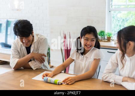 Eltern beobachten ein Mädchen der Grundschule, das studiert Stockfoto