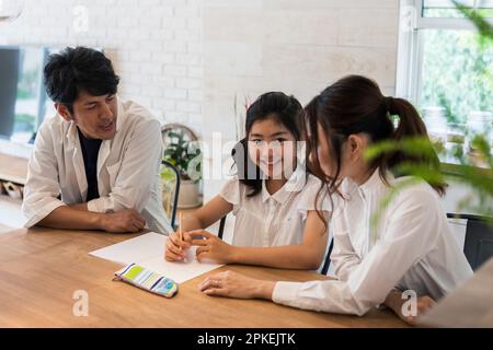 Eltern beobachten ein Mädchen der Grundschule, das studiert Stockfoto