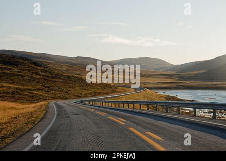 Eine leere kurvige Küstenstraße in Nordnorwegen Stockfoto